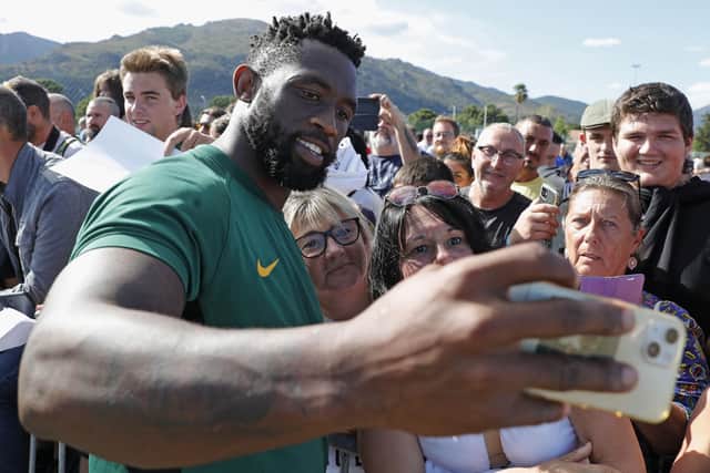 South Africa's Siya Kolisi takes selfies with fans after attending a training session in Biguglia near Bastia on the French Mediterranean island of Corsica where they are preparing for the Rugby World Cup.  (Photo by PASCAL POCHARD-CASABIANCA/AFP via Getty Images)