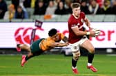Huw Jones (R) runs away from Australia's Len Ikitau during the British and Irish Lions victory at Melbourne Cricket Ground. (Photo by WILLIAM WEST/AFP via Getty Images)