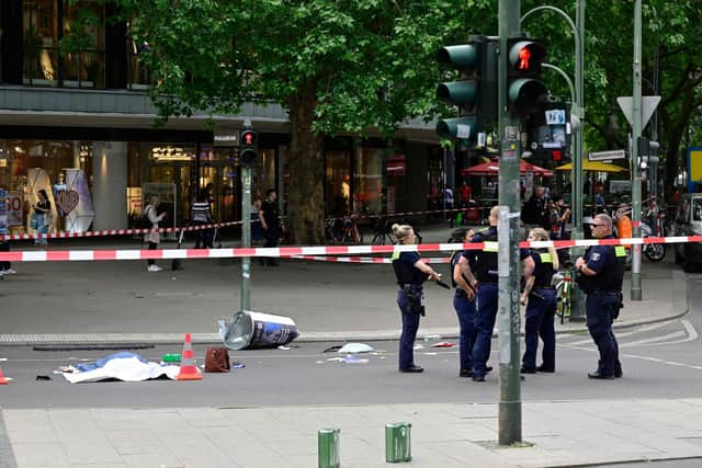 Police stand near a body in a cordoned-off area where a car ploughed into a crowd near Tauentzienstrasse in central Berlin, on June 8, 2022.  A police spokeswoman said the driver was detained at the scene after the car ploughed into a shop front along busy shopping street Tauentzienstrasse. It was not clear whether the crash was intentional. (Photo by John MACDOUGALL / AFP) (Photo by JOHN MACDOUGALL/AFP via Getty Images)