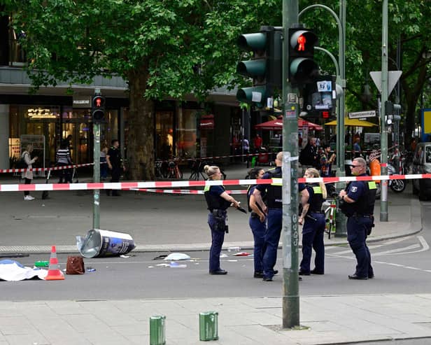 Police stand near a body in a cordoned-off area where a car ploughed into a crowd near Tauentzienstrasse in central Berlin, on June 8, 2022.  A police spokeswoman said the driver was detained at the scene after the car ploughed into a shop front along busy shopping street Tauentzienstrasse. It was not clear whether the crash was intentional. (Photo by John MACDOUGALL / AFP) (Photo by JOHN MACDOUGALL/AFP via Getty Images)