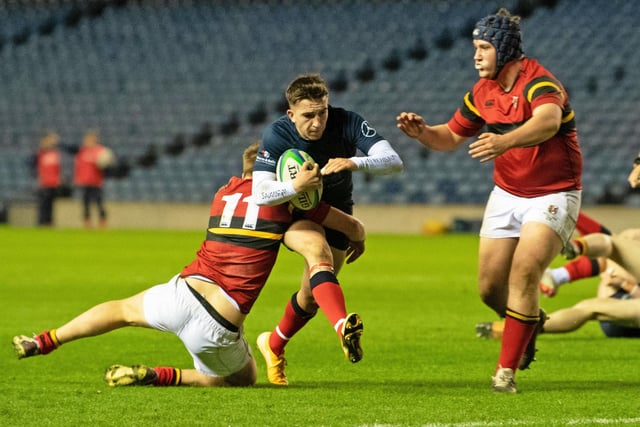 Merchiston's Drew McCall Smith burst through a tackle to score his try