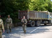US NATO soldiers serving in Kosovo patrol next to a road barricade set up by ethnic Serbs near the town of Zubin Potok.