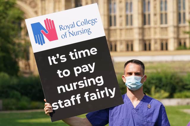 A nurse with a placard outside the Royal College of Nursing in Victoria Tower Gardens, London. Picture Jonathan Brady/PA Wire