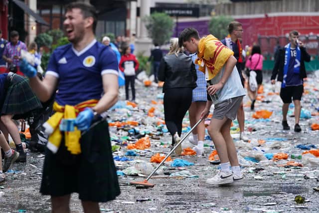 Scotland fans wpn friends by cleaning up litter in central London following the Euro 2020 game against England (Kirsty O'Connor/PA)