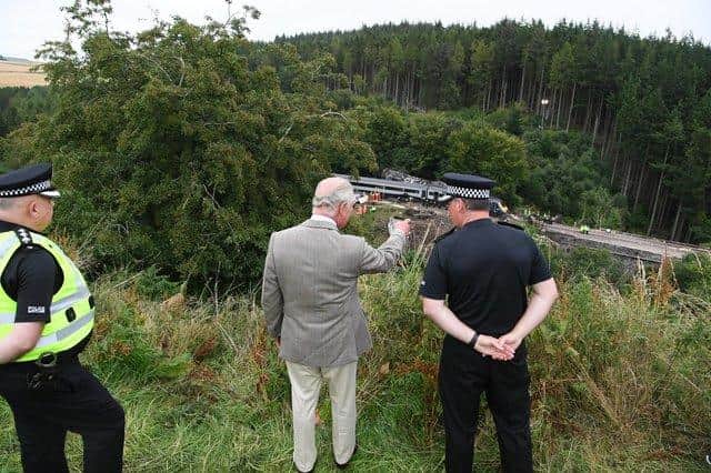The Prince of Wales looks over at the scene of the ScotRail train derailment near Stonehaven, Aberdeenshire, which cost the lives of three people. (Credit: Ben Birchall/PA Wire)