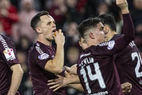 Hearts' Lawrence Shankland eats a pie that was thrown at him during the Edinburgh derby.