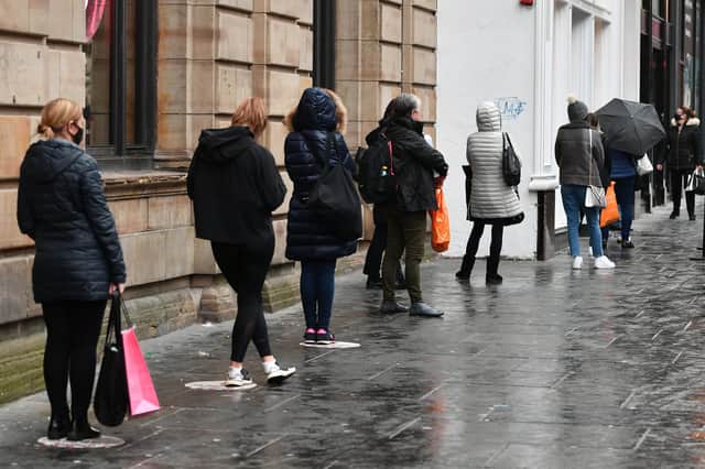 When will this all be over? Shoppers in Glasgow formed a socially distanced queue last week as the city prepared to go into a three-week, tier-four lockdown (Picture: John Devlin)