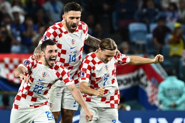 Celtic defender Josip Juranovic celebrates with Croatia team-mates Marko Livaja and Lovro Majer after the penalty shoot-out win over Japan in the last 16 of the World Cup. (Photo by JEWEL SAMAD/AFP via Getty Images)