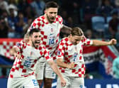 Celtic defender Josip Juranovic celebrates with Croatia team-mates Marko Livaja and Lovro Majer after the penalty shoot-out win over Japan in the last 16 of the World Cup. (Photo by JEWEL SAMAD/AFP via Getty Images)