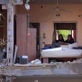 Palestinian women sit in a multi-storey building after a wall collapsed when it was hit by an Israeli airstrike (Picture: Emmanuel Dunand/AFP via Getty Images)