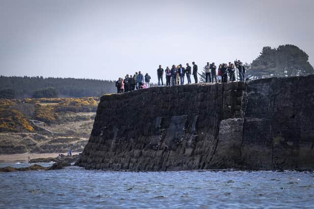 People watch from the harbour wall as young sailors from Gordonstoun lay a wreath.