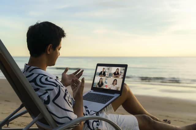 Working online from a tropical beach with laptop. Pic: Alamy/PA.