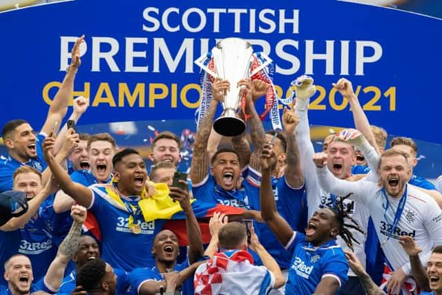 Jubilant Rangers players celebrate as captain James Tavernier holds up the Premiership trophy. (Photo by Craig Williamson / SNS Group)