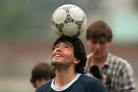 Diego Maradona balances a ball on his head as he walks off the Argentina training pitch in 1986.