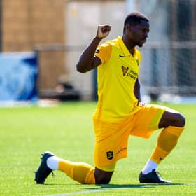 Livingston midfielder Marvin Bartley supports football's anti-racism movement by taking a knee ahead of a match this season. Photo by Ross MacDonald / SNS Group