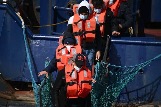 A group of migrants disembark from a UK Border Force boat at the port of Dover having being picked up crossing the English Channel from France.