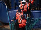 A group of migrants disembark from a UK Border Force boat at the port of Dover having being picked up crossing the English Channel from France.