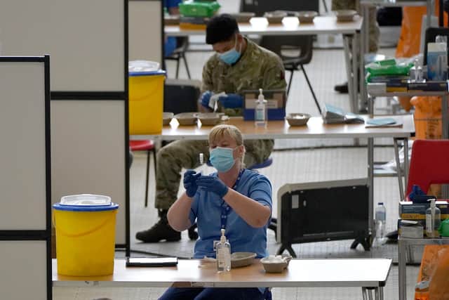 A nurse with a vial of vaccine at the vaccination centre at Ravenscraig Regional Sports Facility in Motherwell, Scotland. Picture date: Friday June 11, 2021.