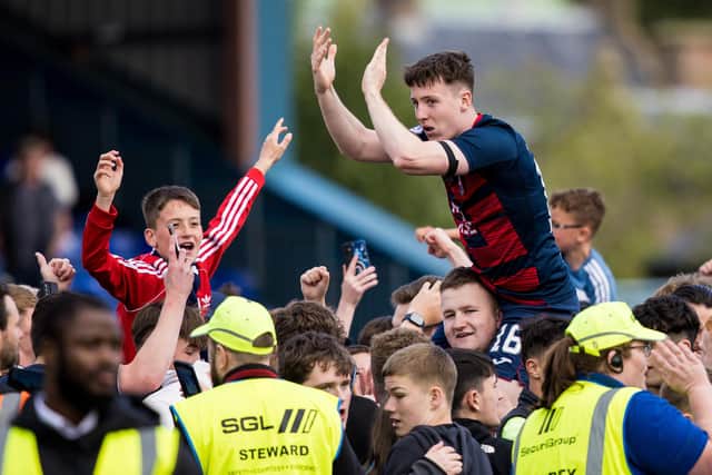 DINGWALL, SCOTLAND - JUNE 04: George Harmon of Ross County celebrates with the fans at full time after the Staggies survived the drop.