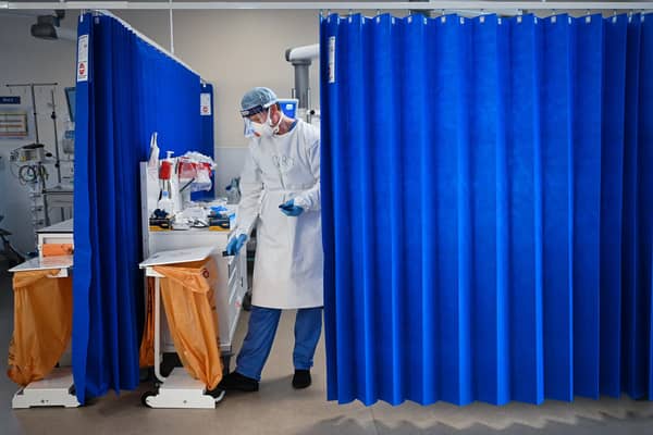 A Nurse at University Hospital Monklands disposes of medical waste. Photo by Jeff J Mitchell/Getty Images