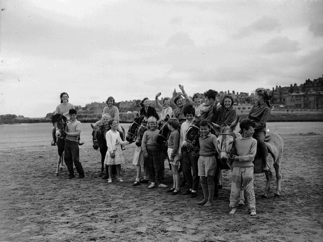 Tourists enjoying the heatave of summer 1961 with the donkeys on St Andrews Beach.