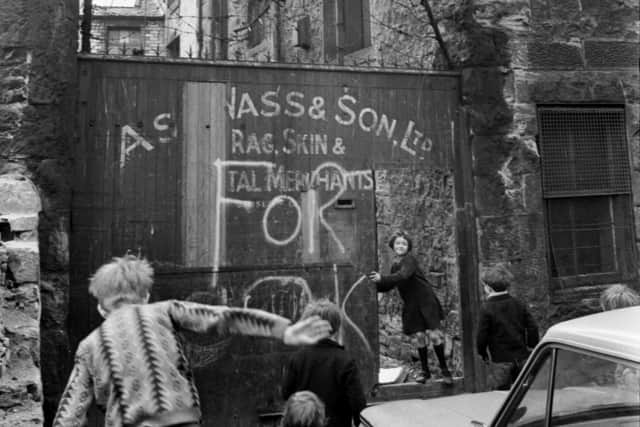 Children playing outside the gates of Asa Wass 'Rag Skin & Metal Merchants in Fountainbridge in April 1969.