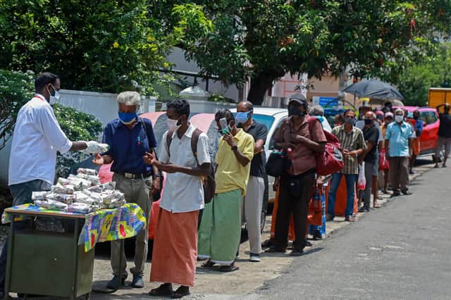 A non-governmental organisation distributes free food packets to the poor people in Kochi earlier this month as the Covid outbreak continues (Picture: Arunchandra Bose/AFP via Getty Images)