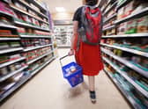 A shopper walking through the aisle of a Tesco supermarket. Picture: Yui Mok/PA Wire