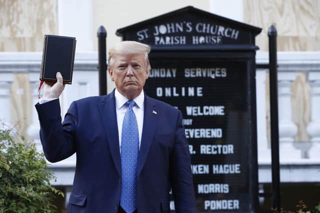 President Donald Trump holds a Bible as he visits outside St. John's Church near the White House (Picture: Patrick Semansky/AP)