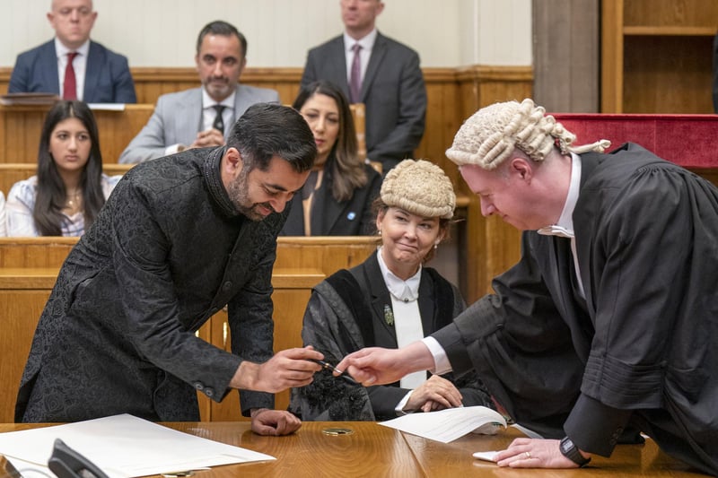 Humza Yousaf signs the parchments as he is sworn in as First Minister of Scotland at the Court of Session