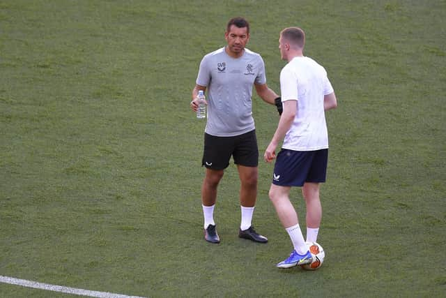 Rangers' head coach Giovanni van Bronckhorst talks with John Lundstram during a training session at the Ramon Sanchez-Pizjuan Stadium in Seville, Spain.(AP Photo/Jose Breton)