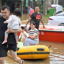 Residents wade through floodwaters after being evacuated from a flooded area following heavy rains in Qingyuan city, in China's southern Guangdong province.