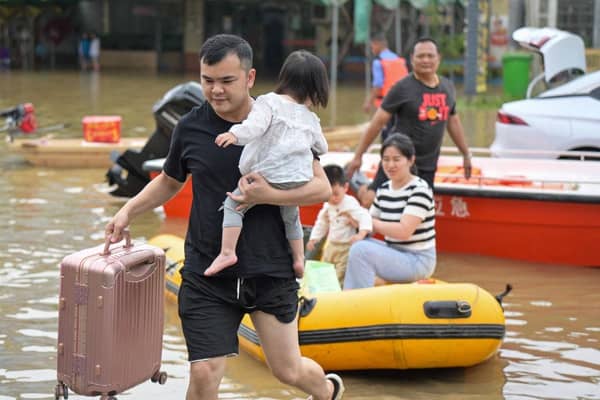 Residents wade through floodwaters after being evacuated from a flooded area following heavy rains in Qingyuan city, in China's southern Guangdong province.