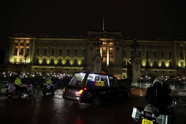 The hearse carrying the coffin of Queen Elizabeth II arrives at Buckingham Palace, London, where it will lie at rest overnight in the Bow Room. Picture date: Tuesday September 13, 2022.
