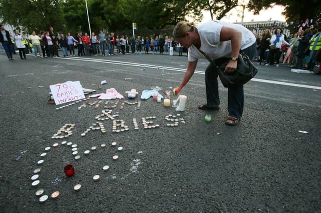 A woman leaves a candle during a march and vigil in Dublin in memory of babies who died at a Mother and Baby Home (Picture: Brian Lawless/PA Wire)