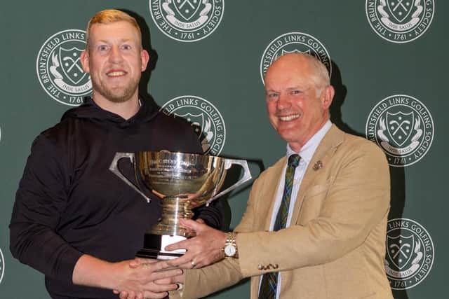 Andrew Fairnie, left, receives the trophy from club captain Graeme Taylor after completing a hat-trick of straight victories at Bruntsfield Links Golfing Society in Edinburgh.
