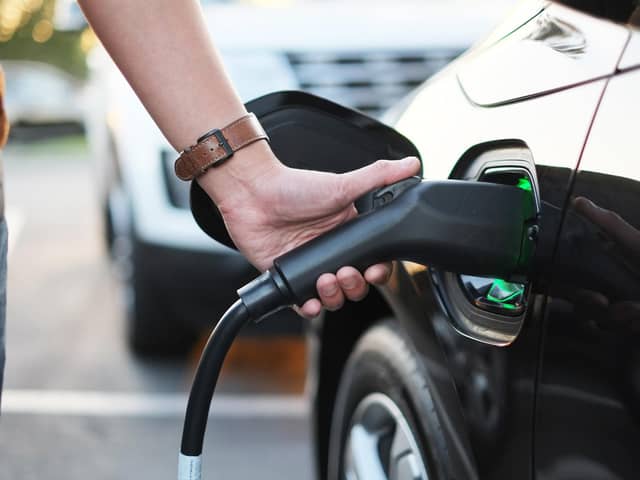 A man at the power supply for electric car charging station.  charging the battery of the vehicle. Picture: Adobe Stock