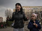 Julia, 34, cries next to her daughter Veronika, 6, while talking to a group of journalists in Brovary, on the outskirts of Kyiv, Ukraine, Tuesday, March 29, 2022. (AP Photo/Rodrigo Abd)