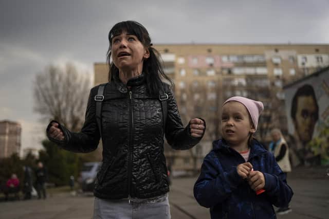 Julia, 34, cries next to her daughter Veronika, 6, while talking to a group of journalists in Brovary, on the outskirts of Kyiv, Ukraine, Tuesday, March 29, 2022. (AP Photo/Rodrigo Abd)