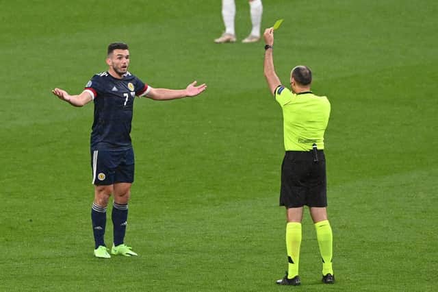 Scotland's midfielder John McGinn is shown a yellow card during the UEFA EURO 2020 Group D football match between England and Scotland at Wembley Stadium in London on June 18, 2021. (Photo by FACUNDO ARRIZABALAGA / POOL / AFP) (Photo by FACUNDO ARRIZABALAGA/POOL/AFP via Getty Images)