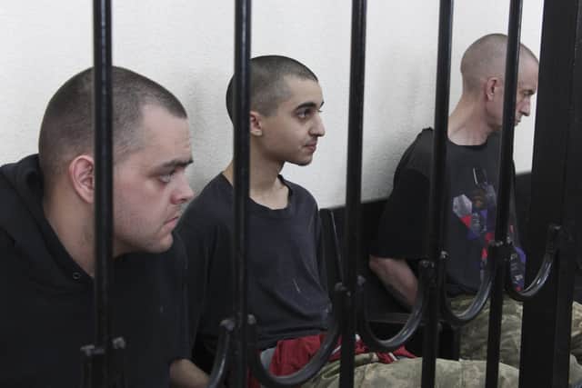 Two British citizens Aiden Aslin, left, and Shaun Pinner, right sit behind bars in a Russian-backed courtroom in Donetsk.