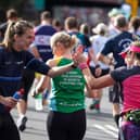 Jill Scott MBE former English professional footballer interacts with runners at the Lucozade Gel Station during the 2022 TCS London Marathon.