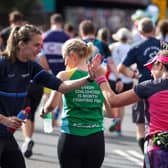 Jill Scott MBE former English professional footballer interacts with runners at the Lucozade Gel Station during the 2022 TCS London Marathon.