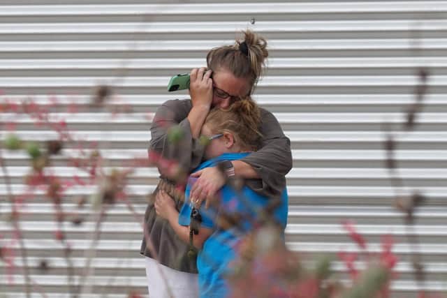 A woman cries and hugs a young girl while on the phone outside the Willie de Leon Civic Center where grief counseling will be offered in Uvalde, Texas, on May 24, 2022.
The attack in Uvalde, Texas -- a small community about an hour from the Mexican border -- is the latest in a spree of deadly shootings in America, where horror at the cycle of gun violence has failed to spur action to end it. (Photo by Allison dinner via Getty Images)
