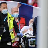 Christian Eriksen is pictured awake on a stretcher as the emergency services remove him from the pitch after administering treatment