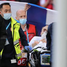 Christian Eriksen is pictured awake on a stretcher as the emergency services remove him from the pitch after administering treatment