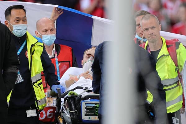 Christian Eriksen is pictured awake on a stretcher as the emergency services remove him from the pitch after administering treatment