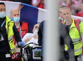 Christian Eriksen is pictured awake on a stretcher as the emergency services remove him from the pitch after administering treatment
