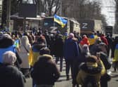 People with Ukrainian flags walk towards Russian army trucks during a rally against the Russian occupation in Kherson. Picture: AP Photo
