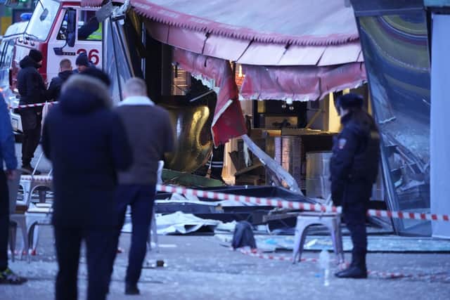 Russian investigators and police officers stand at the side of an explosion at a cafe in St. Petersburg. An explosion tore through a cafe in the Russian city of St. Petersburg on Sunday, and preliminary reports suggested a prominent military blogger was killed and more than a dozen people were injured. (AP Photo)